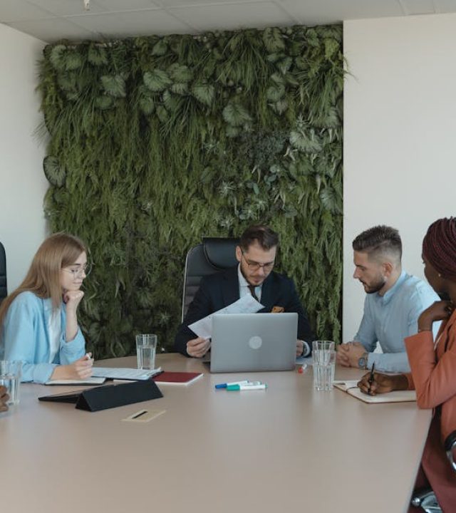 pexels-photo-5439471-5439471 A diverse team brainstorms in a modern office with green wall decor.